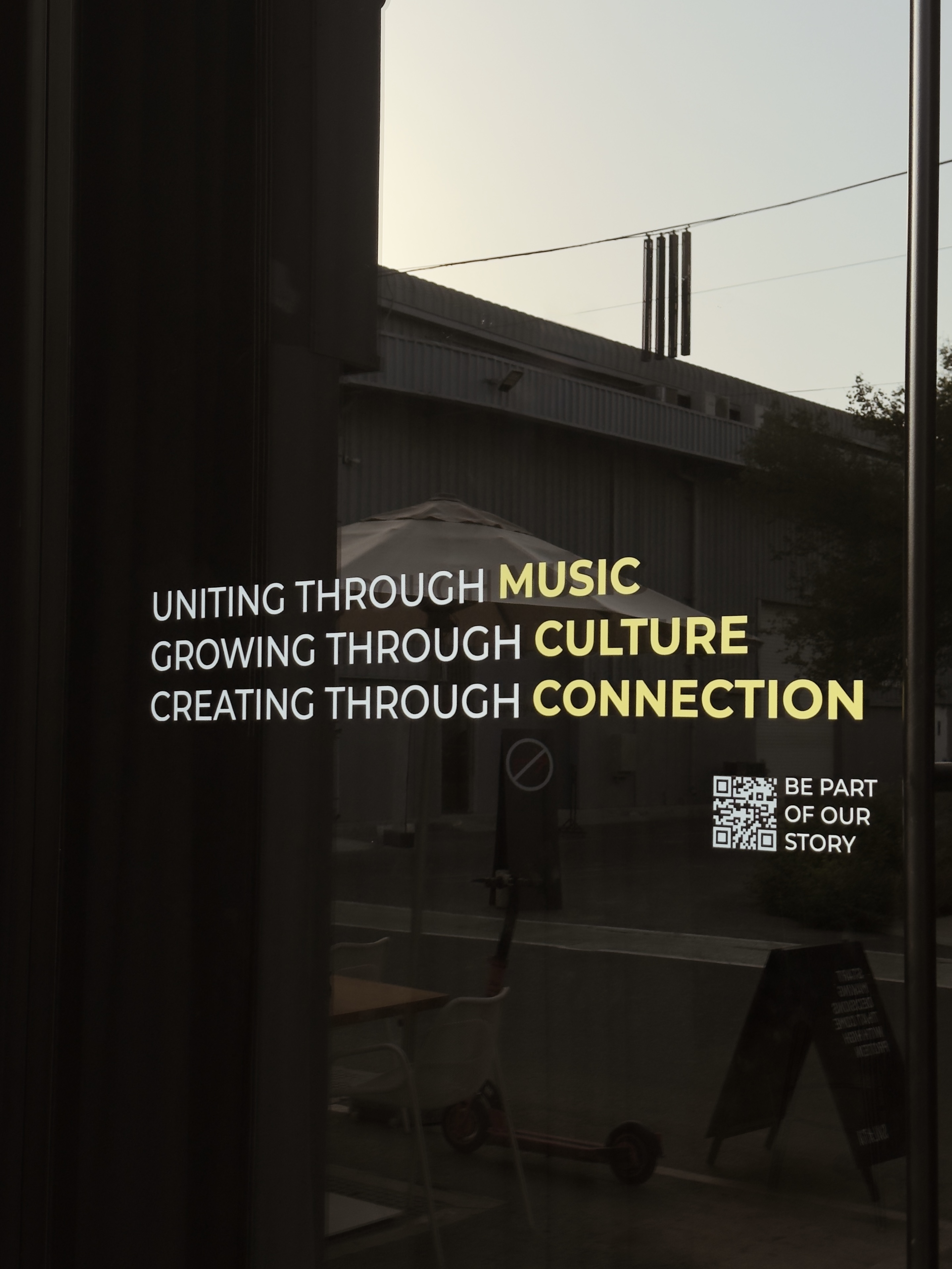 Надпись на стекле: Uniting through music, growing through culture, Alserkal Avenue, Дубай